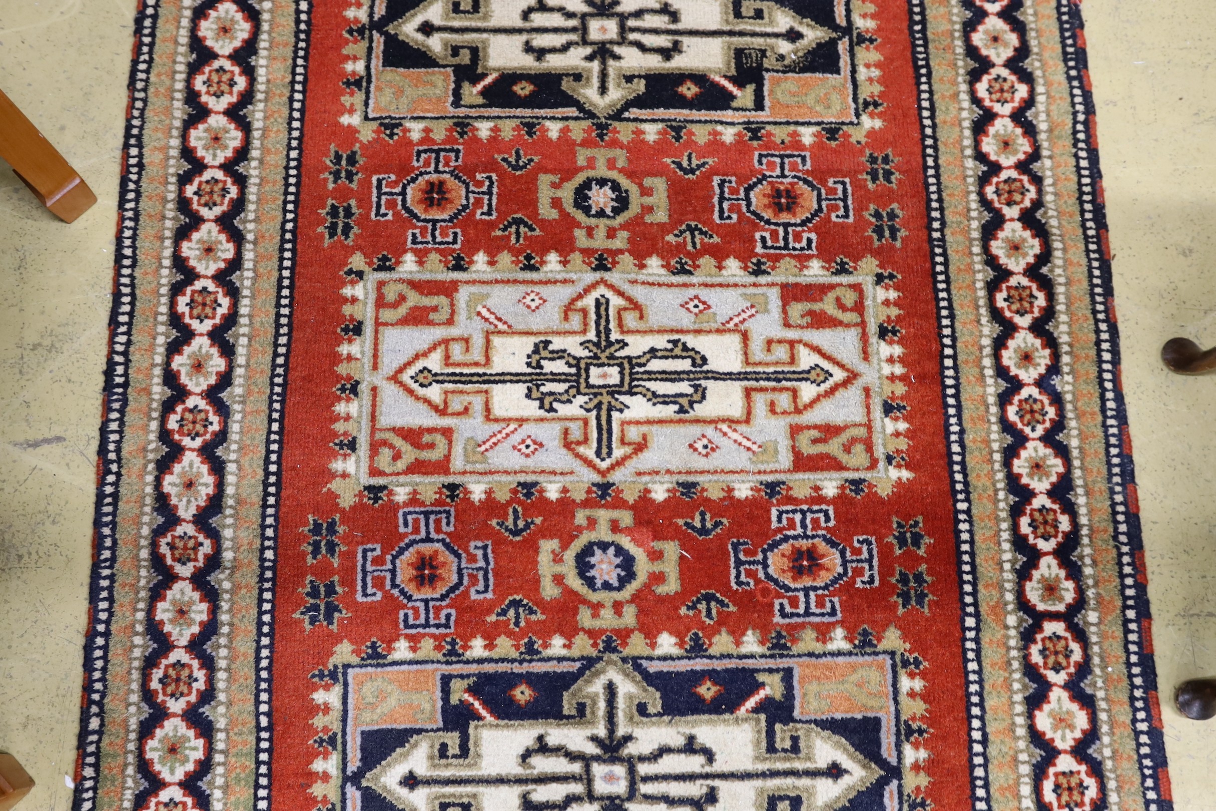 A Caucasian style brick red ground rug, 180 x 128cm